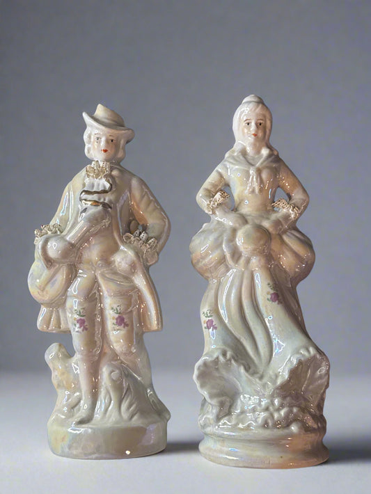 Two ceramic figurines on a dark background